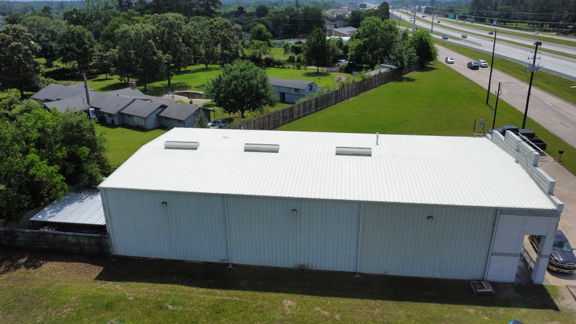 Commercial metal building with a restored white roof system and ridge vents