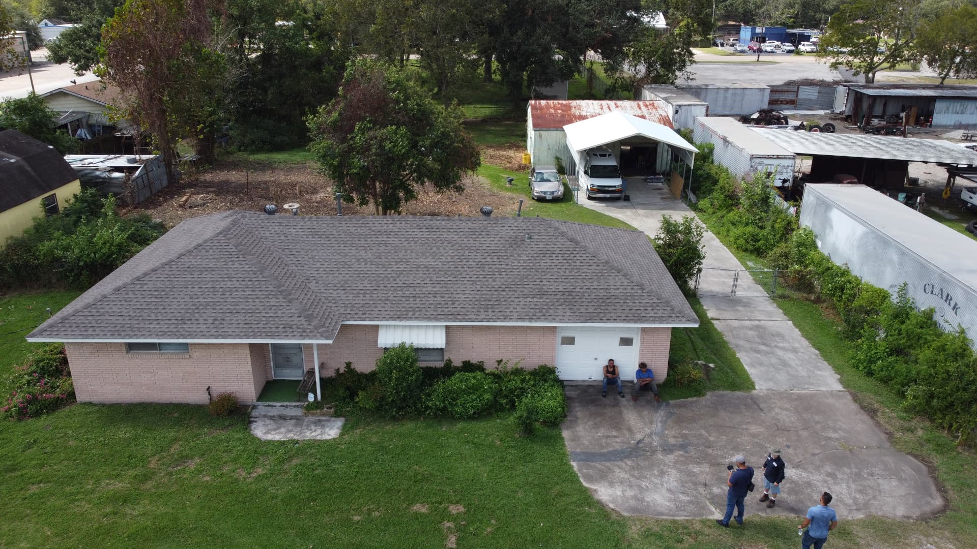 Aerial view of a single-story brick ranch home with a newly installed gray-brown asphalt shingle hip roof by BD Roofing & Contracting